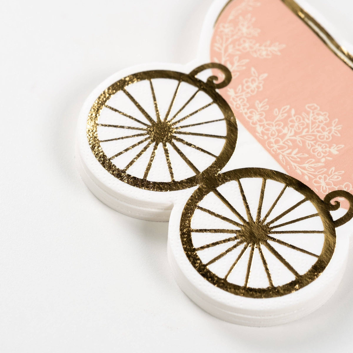 close up of gold wheel detail on baby carriage napkin
