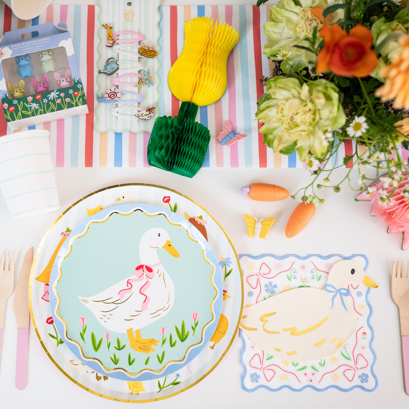 Goose themed party table with silly goose plate, spring decor, and party supplies.
