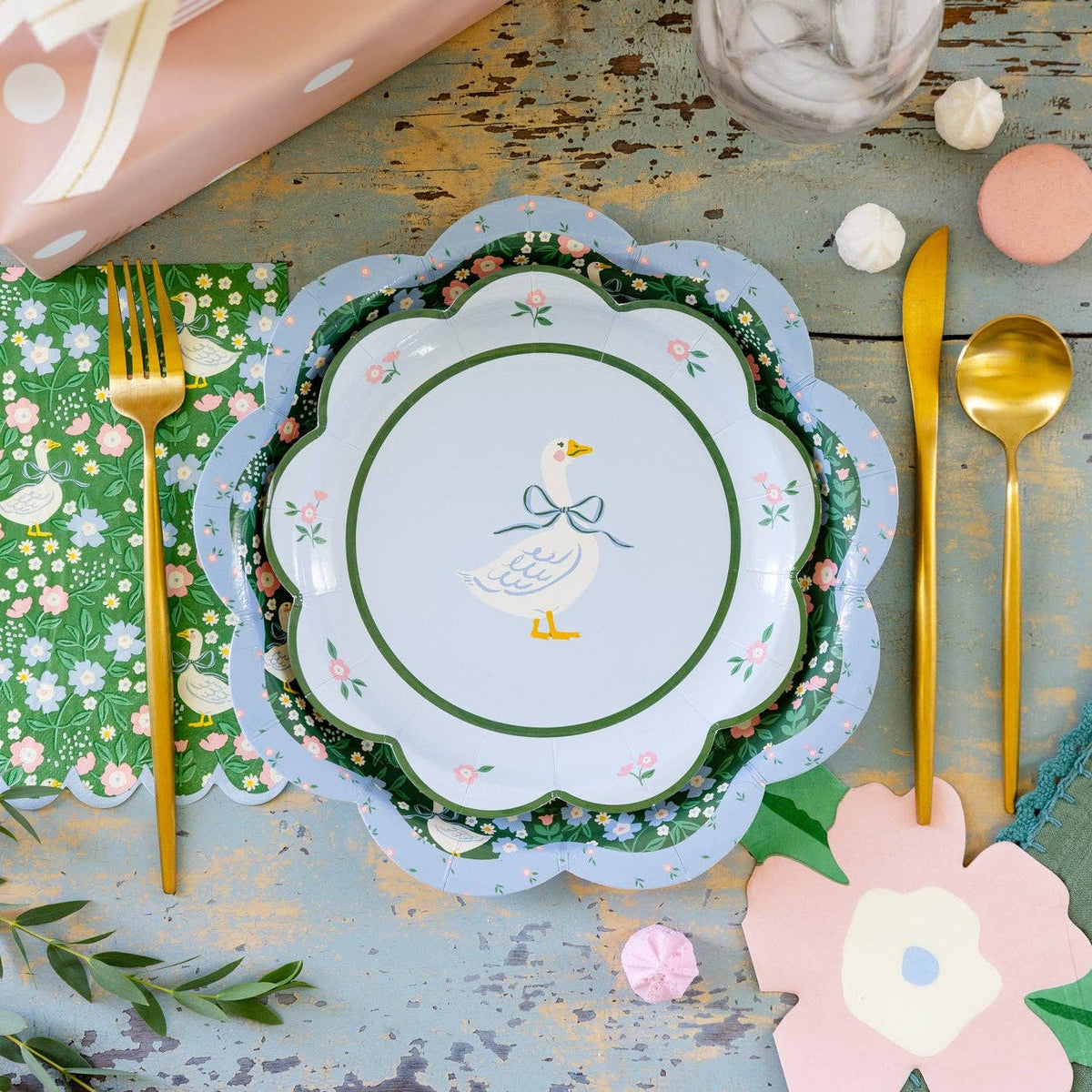 Spring table styled with goose dessert plates, floral napkins, and gold flatware