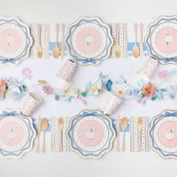 Spring party table featuring goose plates and pastel decorations.
