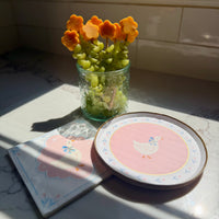 Goose designed plate and napkin with fresh fruits on a glass.