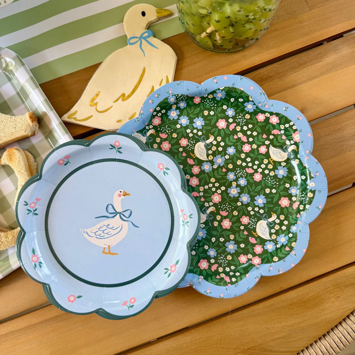 A goose themed paper plate, with a larger goose patterned plate, and a goose shaped napkin, top view.