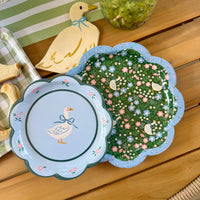 A goose themed paper plate, with a larger goose patterned plate, and a goose shaped napkin, top view.