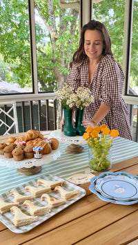 A goose themed table with a woman at the side featuring the sage green table runner.