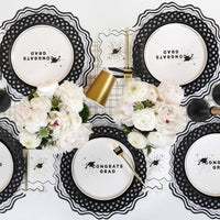 Overhead view of a sophisticated tablescape featuring grad cap napkins ready for a commencement toast.