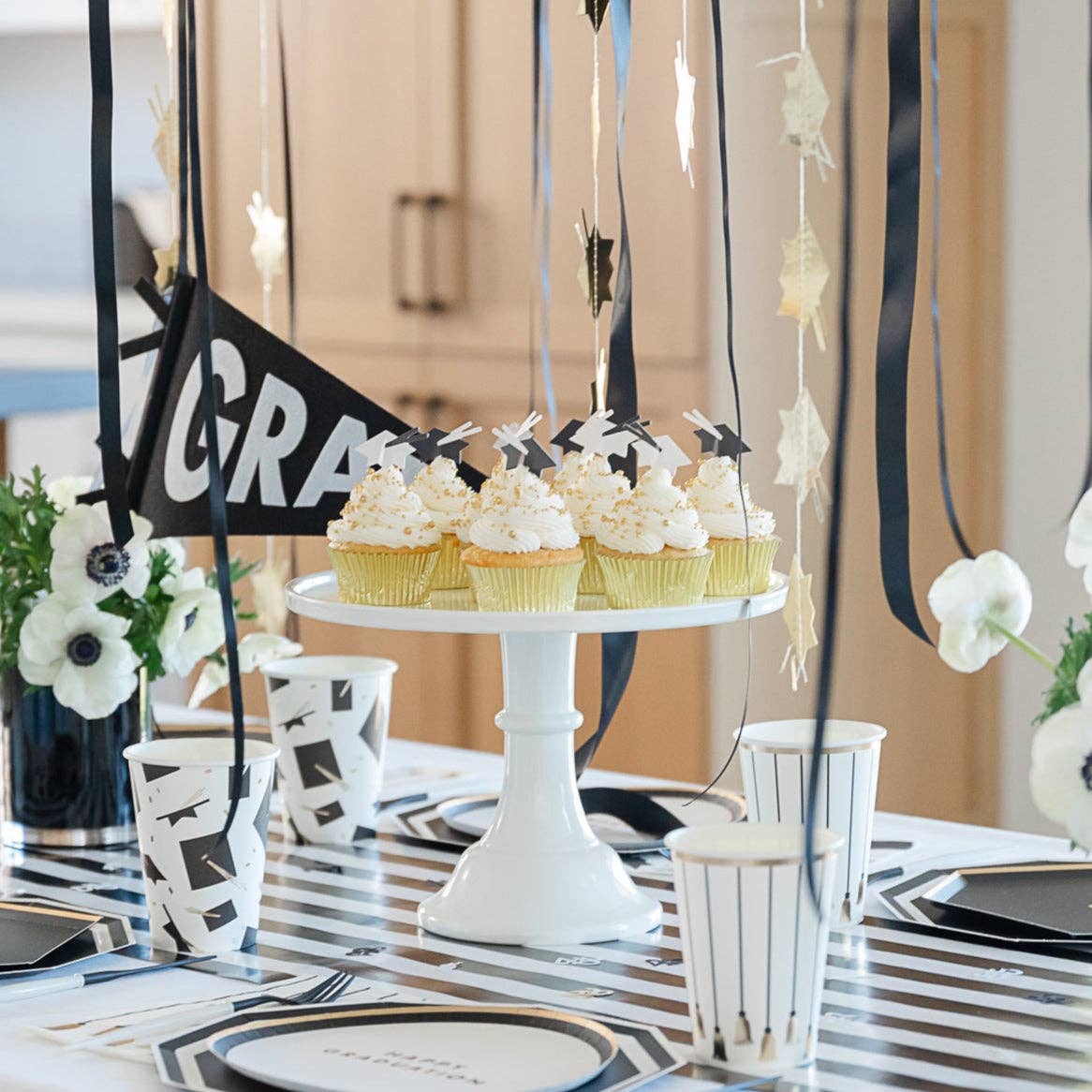 Graduation dessert table with cupcakes and grad hat toppers