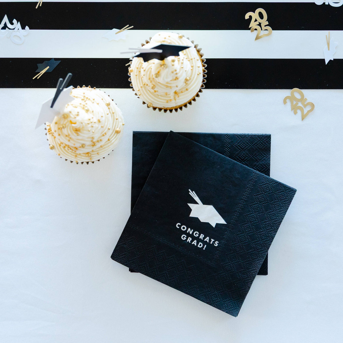 Graduation party setup with cupcakes and black “Congrats Grad” napkins