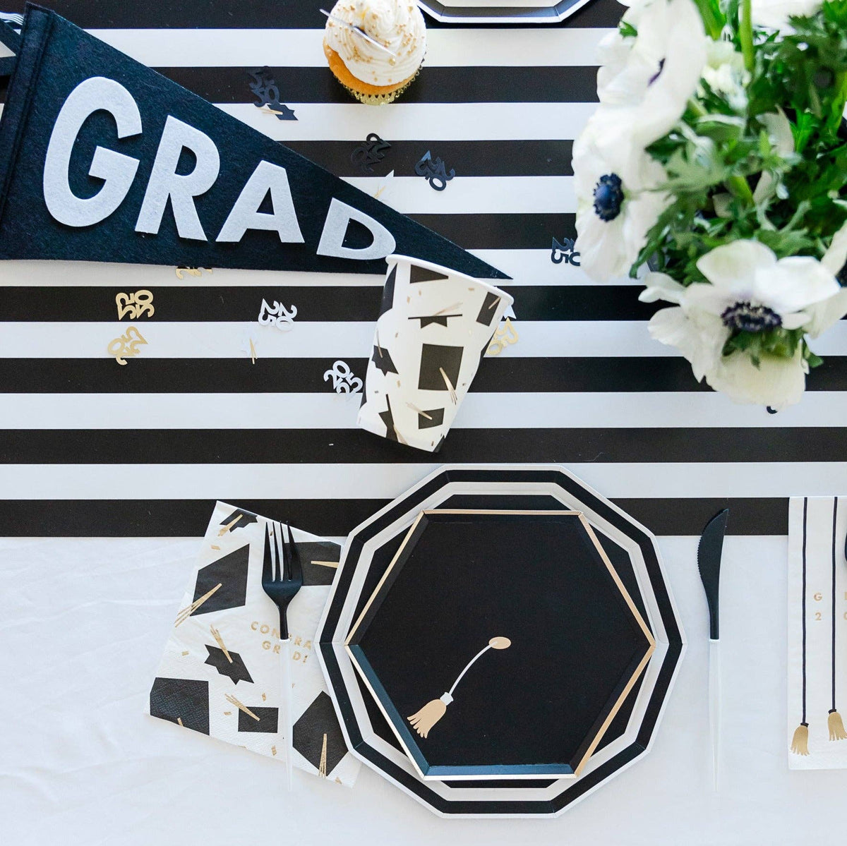 Graduation party table with black and white decor and tassel lunch napkins
