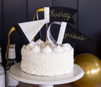 Graduation cake decorated with hooray congrats and graduate mini felt pennants
