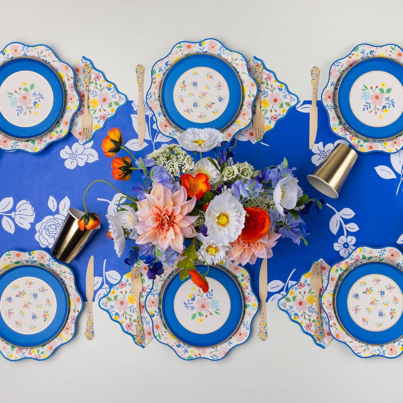 Elegant floral cake plates styled on a colorful garden party table.
