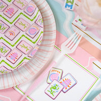 Tight close-up on the pink and green border of the Mahjong Cocktail Napkins next to game tiles.
