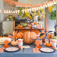 Thanksgiving kitchen table with pumpkins and garlands; plaid “Grateful” cups and matching guest towels at each place.
