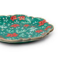 Stack of green floral Christmas paper plates showing the scalloped gold-trimmed edge and floral pattern from an angle.