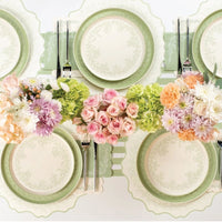 green cocktail napkins arranged with floral centerpieces and tableware.