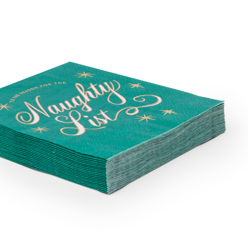 Angled stack of green Naughty List cocktail napkins showing the gold-foil lettering and the full set depth.