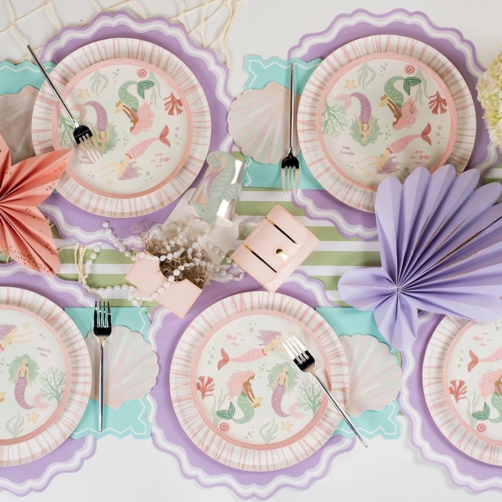 green paper table runner with mermaid plates and table setting.