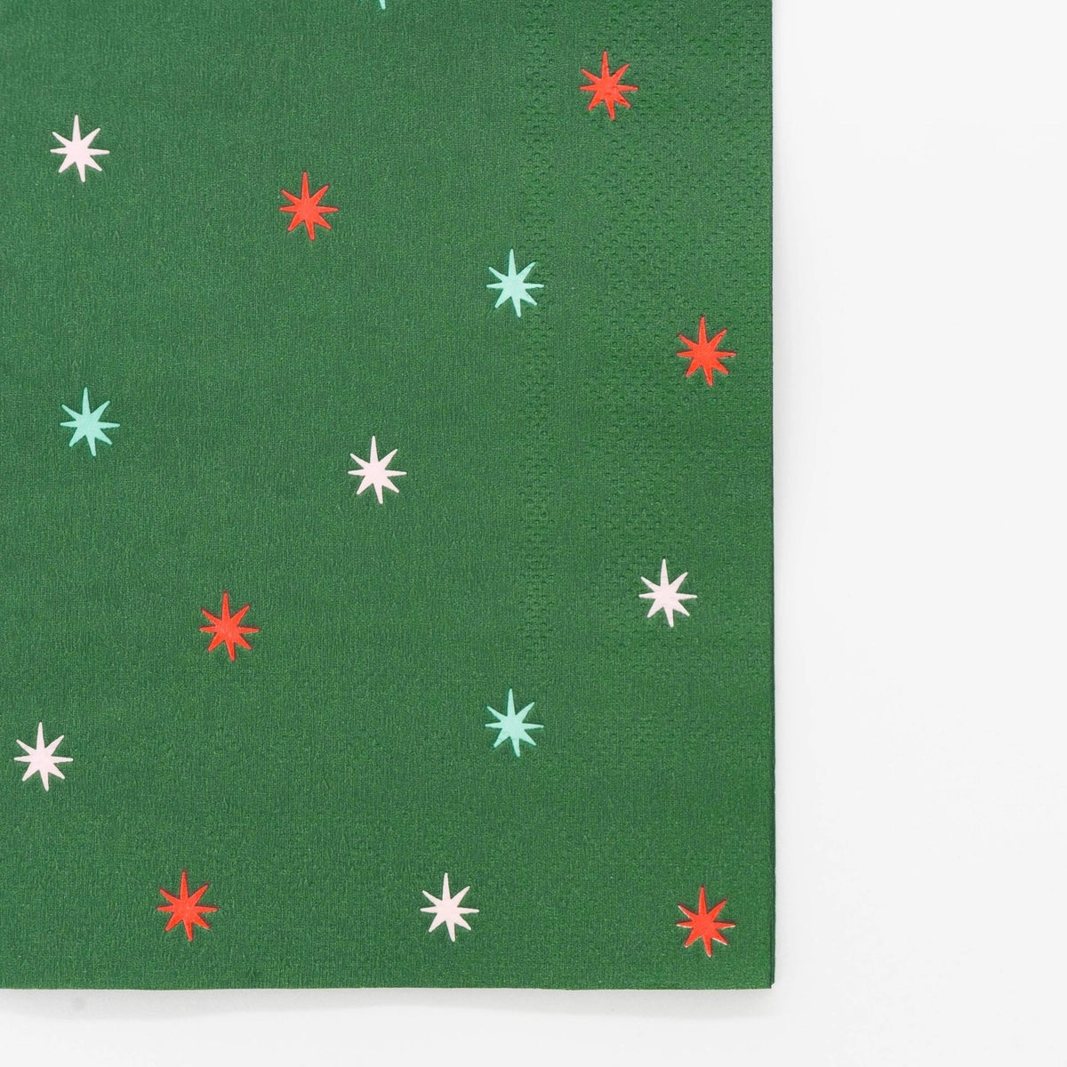 Green star guest towel laid flat, showing the evergreen ground and scattered starbursts.