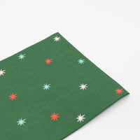 Green star guest towel laid flat, showing the evergreen ground and multicolor starbursts.