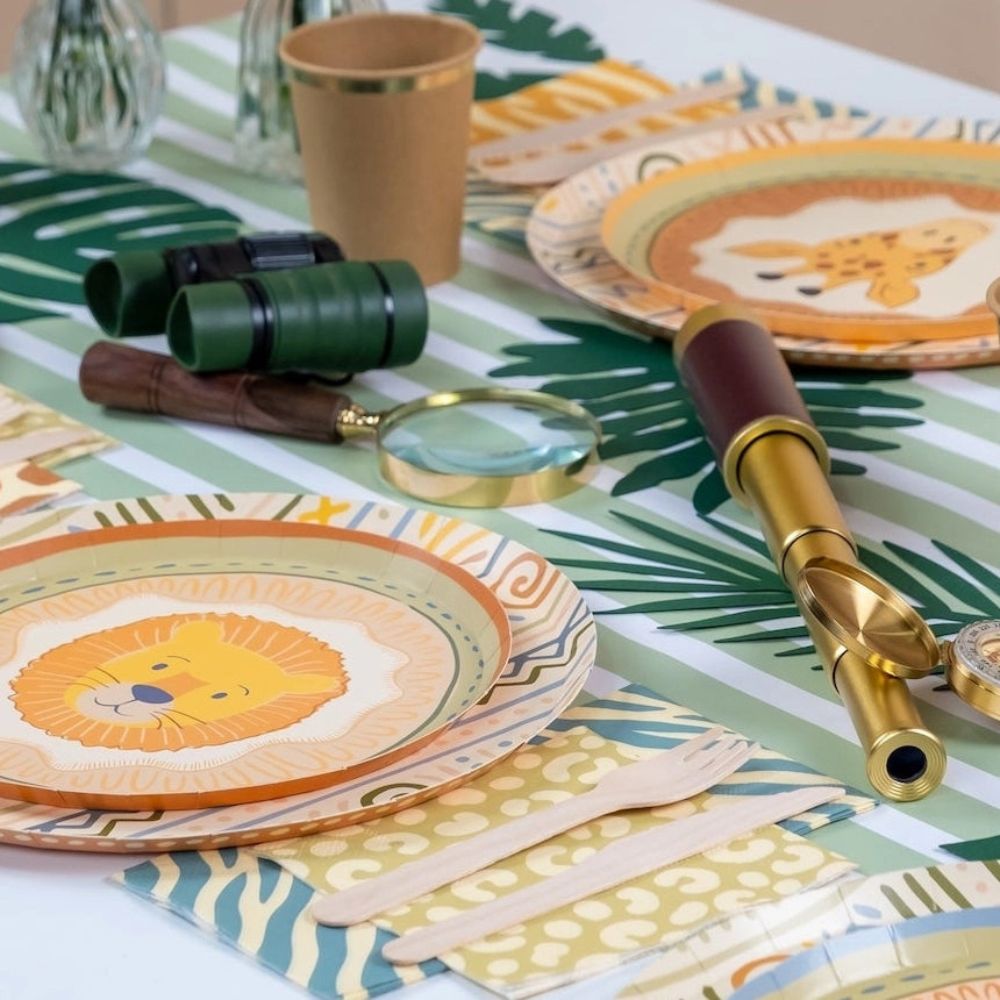 green striped paper table runner with safari table setup and party plates.