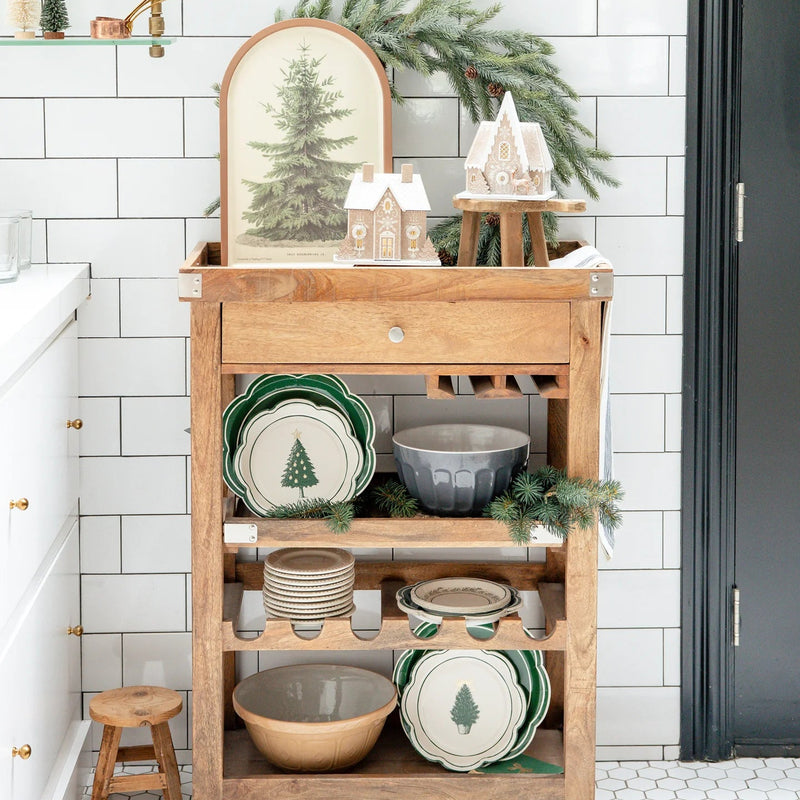 Full view of kitchen cart with disposable dinner plates and other Christmas Lane items, featuring the large green scalloped plates.