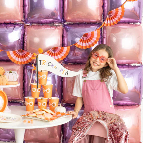 Party table styled with balloons and Groovy Pumpkin cups, banner and treats—perfect inspiration for disposable Halloween cup setup.