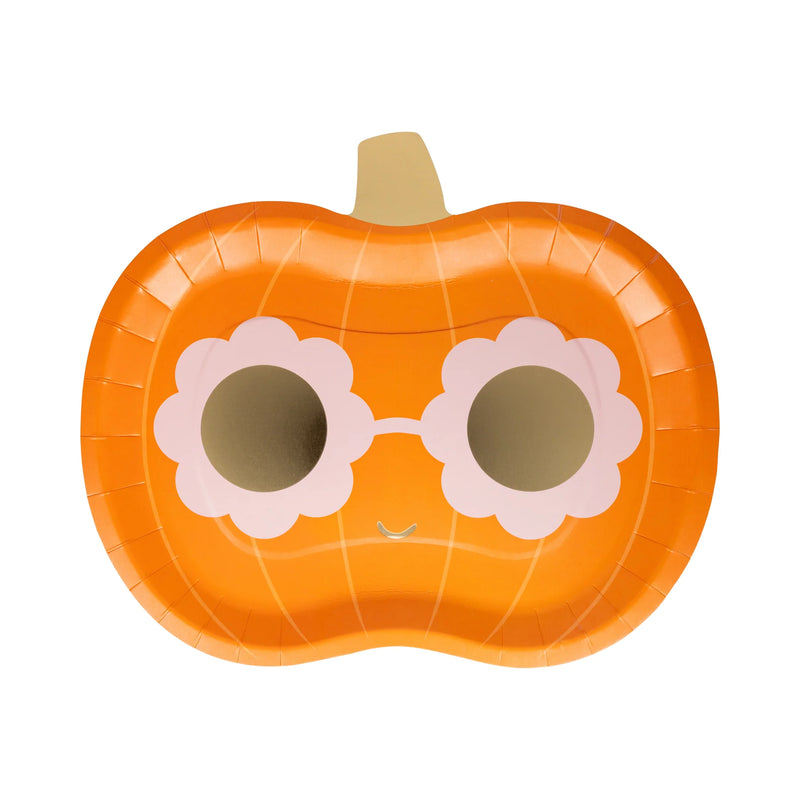 Isolated product shot of a groovy Halloween paper plate shaped like a bright orange pumpkin (approx. 11 × 9 in.). The whimsical design shows retro pink daisy-shaped sunglasses with shiny gold-foil lenses, a subtle smile, soft pumpkin ridges, and a gold-foil stem—eye-catching disposable tableware perfect for funky Halloween paper plates place settings, treat tables, classroom parties, or fall bake-sale goodies.