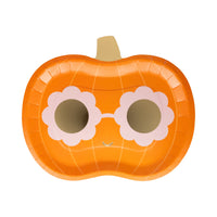 Pumpkin-shaped paper plate with flower sunglasses on a white background