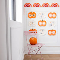 Gallery wall styled with groovy halloween pumpkin plates and “Trick or Treat” speech-bubble plates for playful seasonal decor.