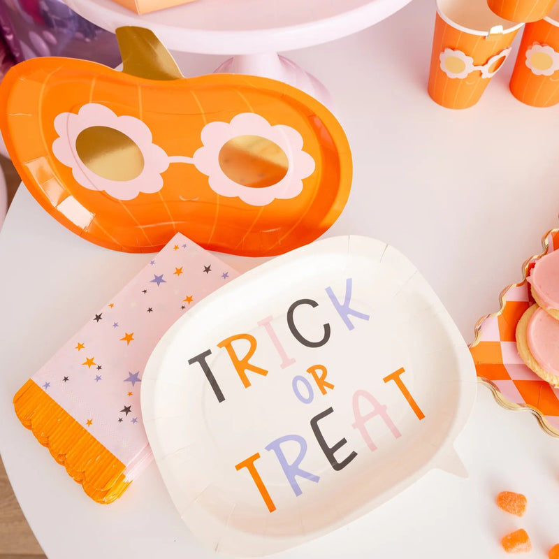 Groovy Stars napkin adds pastel sparkle beside orange pumpkin tray, treat boxes and cups in a colorful Halloween snack setup.