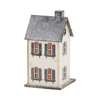 Angled view of the Haberdashery haunted village house highlighting the striped awnings, shutters, and glittered finish.