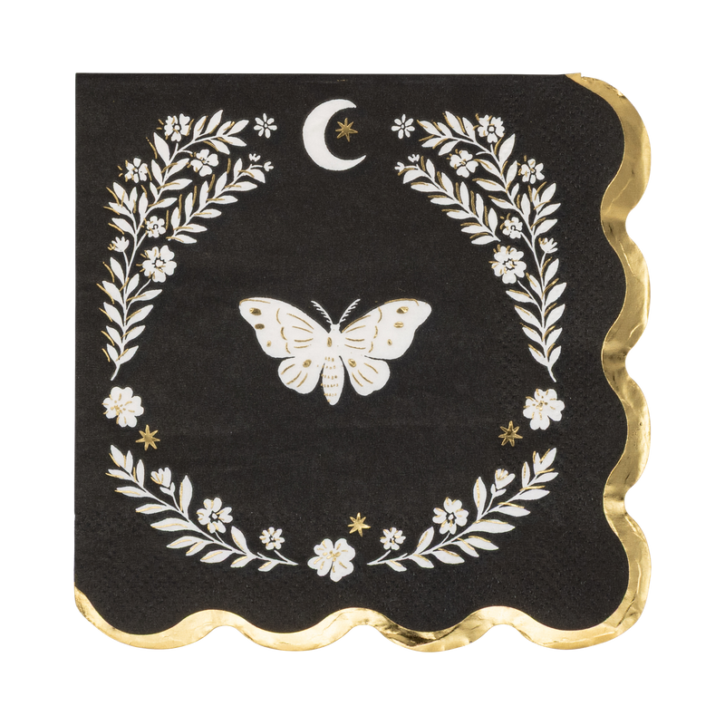 Black Halloween cocktail napkin with a cream moth illustration inside a cream laurel wreath frame and crescent moon, gold foil scalloped edge, overhead view on gray background.
