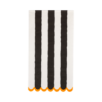 Striped towel with black & white vertical stripes and orange scalloped edge on a white background