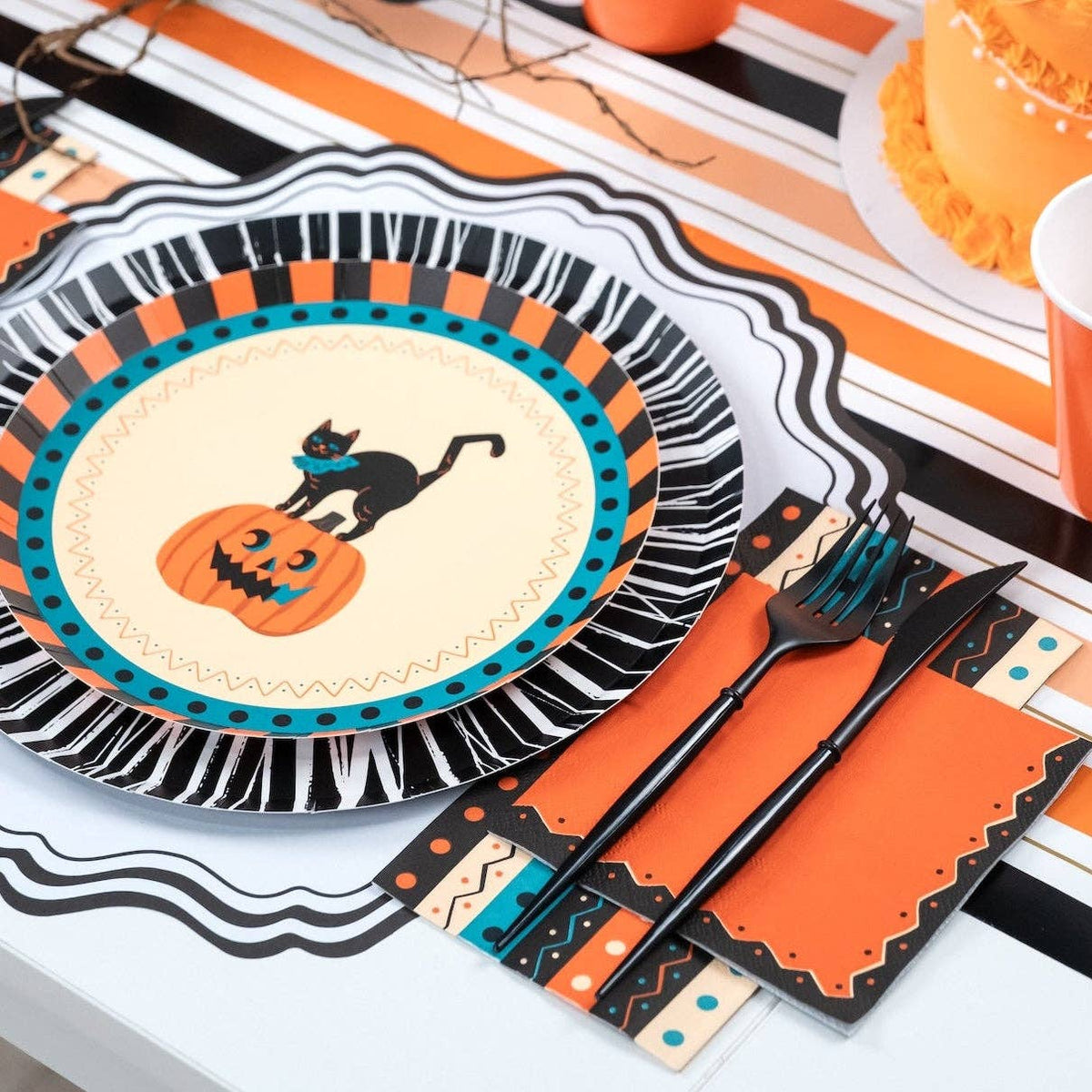 Halloween place setting with the retro striped towel, vintage cat plate, orange napkins, and black flatware.