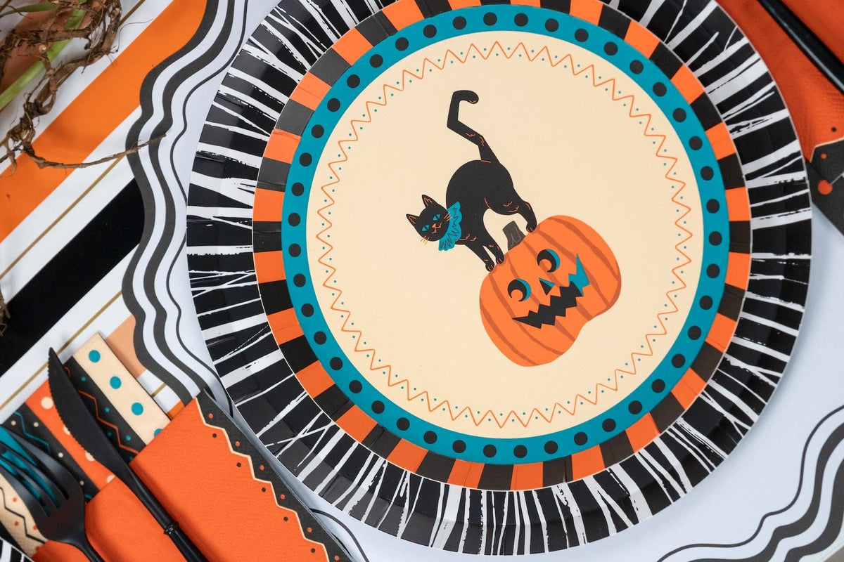 Halloween place setting showing the vintage cat plate layered on a black fringe charger with orange accents.