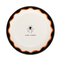 Cream Halloween plate with a black spider icon and "stay creepy" text, black rim and orange scalloped edge.