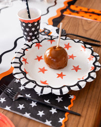 Caramel apple on a plate with Halloween-themed star paper plate.