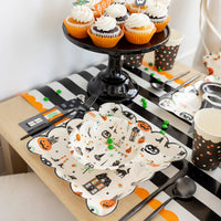 Halloween dessert table featuring square plate, matching bowl and orange-frosted cupcakes.