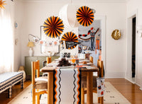 Dining room with Halloween decorations, including Halloween tissue paper fans and a 'Trick or Treat' banner.