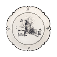 Decorative plate with black and white design of a house and trees on a white background