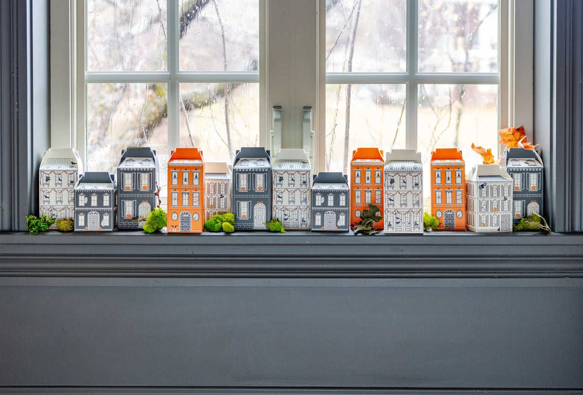 Wide windowsill scene with all 13 Halloween village treat boxes lined up to create a street of houses; ideal for party favors or Halloween countdown.