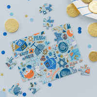 Hanukkah mini puzzle styled on a blue table with gelt and dreidels