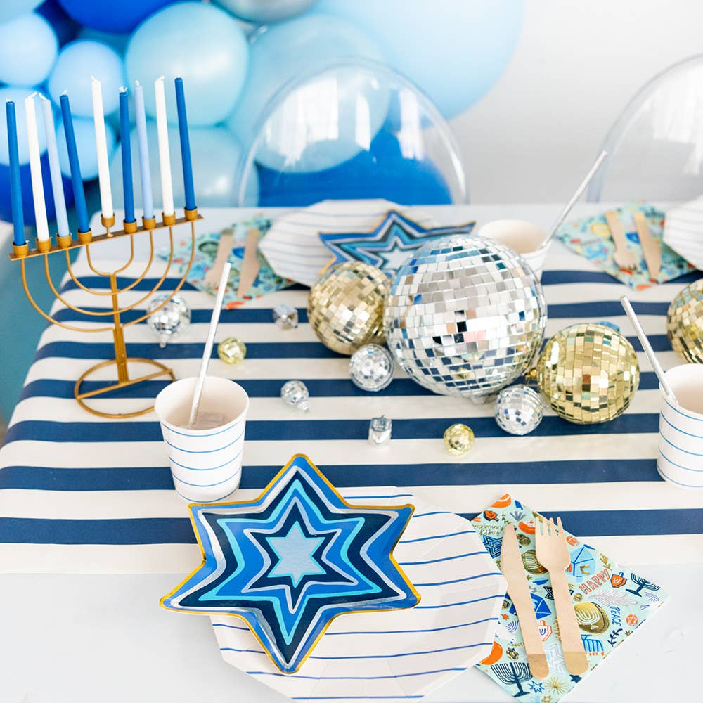 Star of David Hanukkah plates styled on a blue and white party table