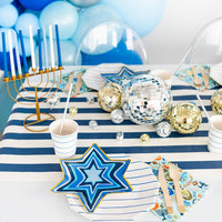 Star of David Hanukkah plates styled on a blue and white party table