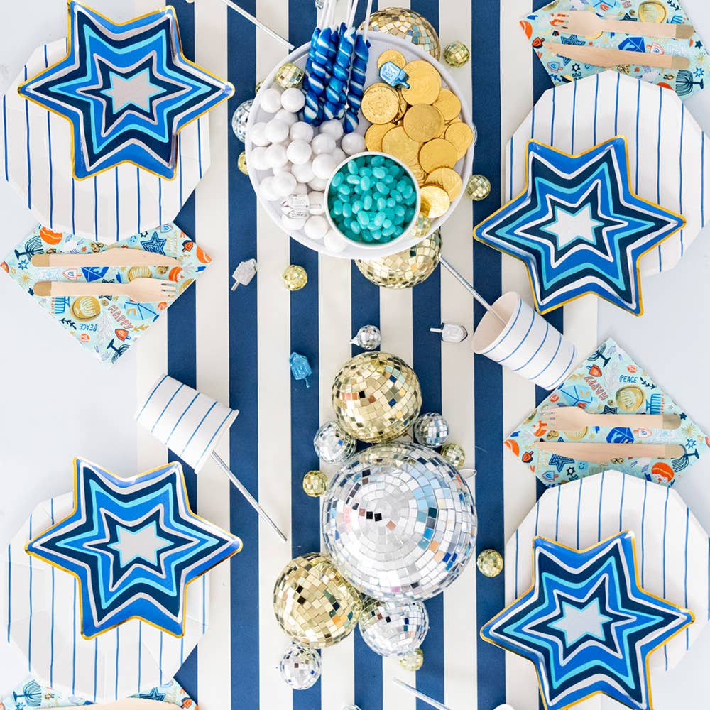Star of David Hanukkah plates styled on a table with foil decorations