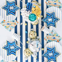 Star of David Hanukkah plates styled on a table with foil decorations