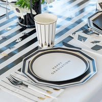 Side view of white graduation snack plate with gold lettering saying "Happy Graduation" with matching cup and napkins