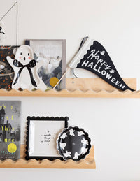 Happy Halloween felt banner on a shelf wall Halloween themed station in a black & white setup.