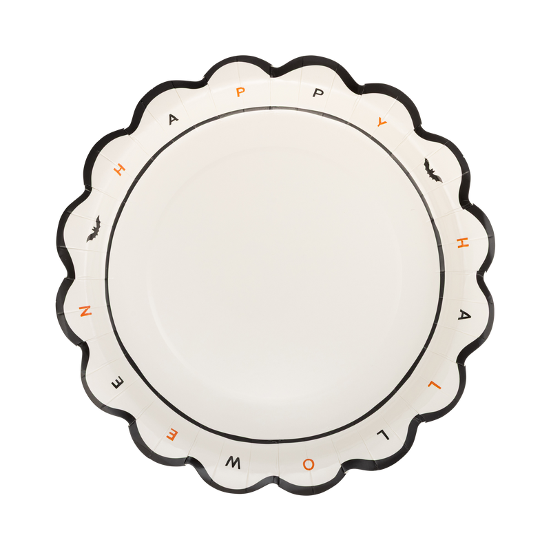 Cream Halloween paper plate with individual "HAPPY HALLOWEEN" letters in black and orange around the rim, tiny bat icons, and a black scalloped edge, overhead flat-lay view.