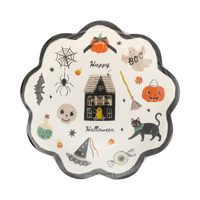 Front of the plate in sealed clear wrap on white background. Full illustration visible through plastic. Black scalloped edge, cream ground, all Halloween icons scattered around a centered haunted house. "Happy" and "Halloween" in black script flanking the house.