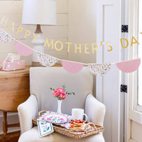 Happy Mother’s Day banner styled over chair with brunch setup